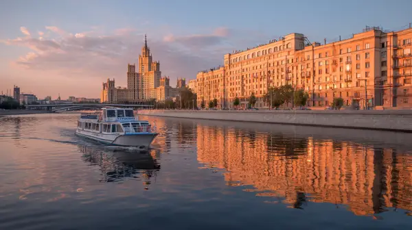 Прогулочный теплоход плывет по Москве-реке на фоне высотки