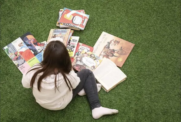 Ребенок изучает иллюстрации к книгам в Российской Государственной Детской Библиотеке