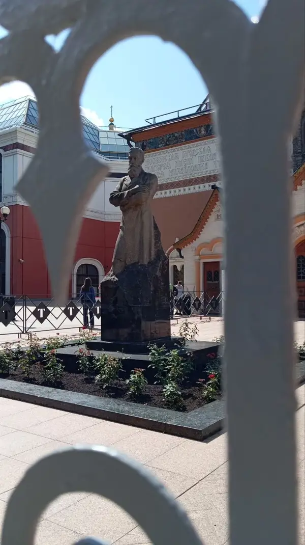 Памятник Павлу Третьякову, видимый сквозь ажурную металлическую решетку